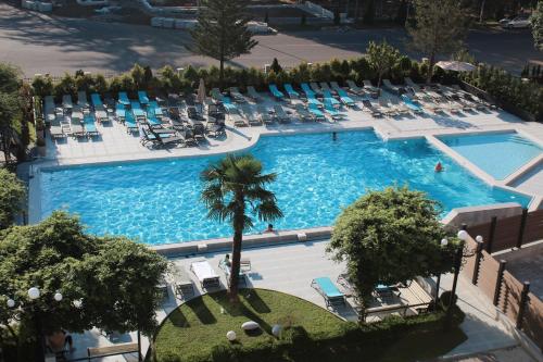 una vista dall'alto di una grande piscina con sedie a sdraio di Tskaltubo Hotel Prometheus a Tskhaltubo