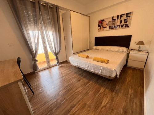 Un dormitorio con una cama y una ventana grande. en Brisa & Beach a 3 Min de la Playa Zapillo, en Almería