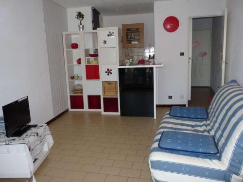 un salon avec un canapé et une cuisine dans l'établissement Studio cabine proche plage, parking privé - FR-1-328-143, à La Grande Motte