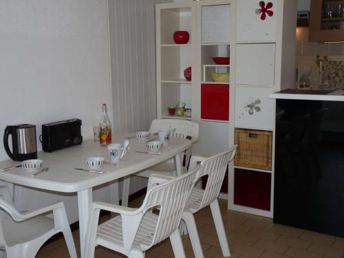 - une cuisine avec une table blanche et des chaises blanches dans l'établissement Studio cabine proche plage, parking privé - FR-1-328-143, à La Grande Motte