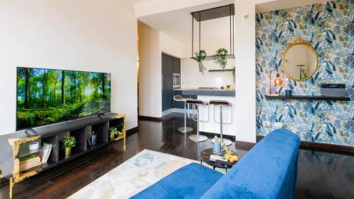 a living room with a blue couch and a fish tank at Elegant Penthouse With A View Of The Two Towers And Piazza Maggiore in Bologna