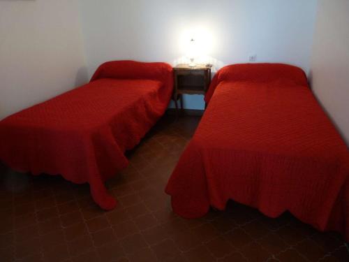 - 2 lits dans une chambre avec des couvertures rouges dans l'établissement Studio avec Loggia, Terrasse & Parking Privé en Centre-Ville, Proche Plage - FR-1-328-99, à La Grande Motte