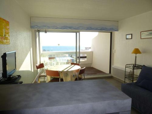 - un salon avec une table et une vue sur l'océan dans l'établissement Studio Cabine Rénové - Proche Plage et Commerces - FR-1-328-198, à La Grande Motte