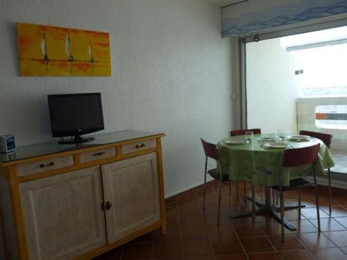 une salle à manger avec une table et une télévision sur une armoire dans l'établissement Studio Cabine Rénové - Proche Plage et Commerces - FR-1-328-198, à La Grande Motte