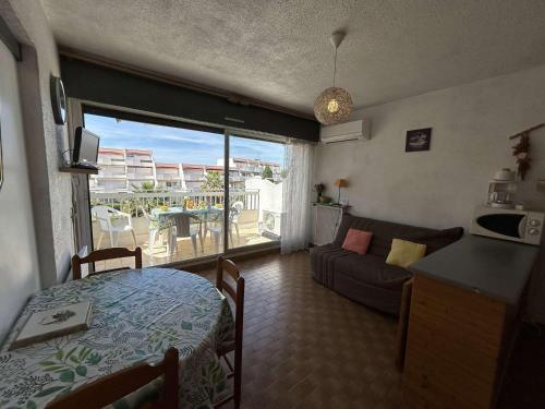 un salon avec un canapé et un salon avec une fenêtre dans l'établissement Appartement 2 pièces avec climatisation, 2 terrasses et accès direct au port - Le Grau-du-Roi - FR-1-250-96, au Grau-du-Roi