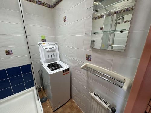 une petite salle de bain avec une machine et un miroir dans l'établissement Appartement 2 pièces avec climatisation, 2 terrasses et accès direct au port - Le Grau-du-Roi - FR-1-250-96, au Grau-du-Roi