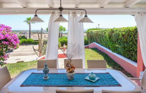 a patio with a table and chairs with a view at Pet Friendly Home In Stintino in Stintino
