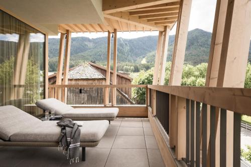 a balcony with chairs and a view of mountains at Falkensteiner Hotel Kronplatz - The Leading Hotels of the World in Brunico