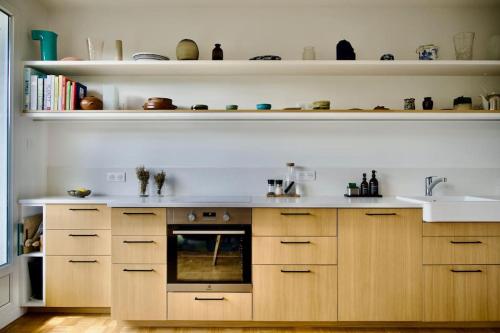 une cuisine avec des armoires en bois et un évier dans l'établissement Magnifique appartement - Parc des Buttes Chaumont, à Paris