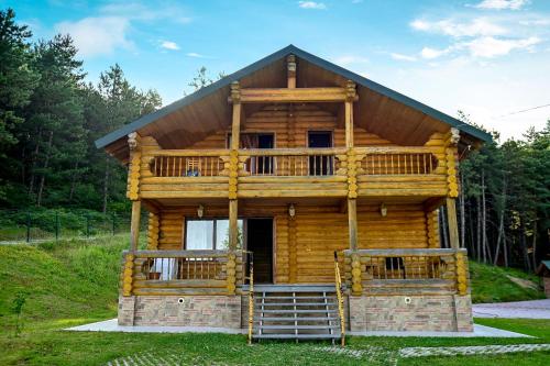 a log cabin with a porch and a deck at Surami Savannah სურამი სავანა in Surami