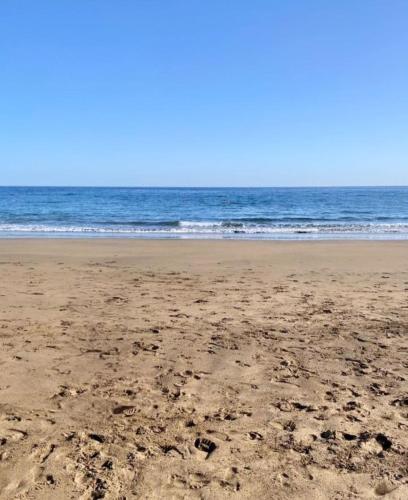 a beach with footprints in the sand and the ocean at Blue Miracle Villa in Arrecife