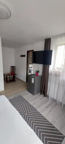 a room with a bed and a living room with a table at CASA RYANA SINAIA in Sinaia