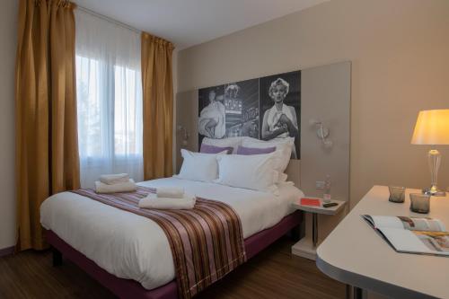 a hotel room with a large bed and a window at Hôtel Arles Plaza in Arles