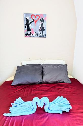 une paire de mitaines posées sur un lit rouge dans l'établissement Chambre tout confort et sympa ! Et nuit calme surtout ! à pied , 5min de la gare ! de la cathédrale ! et des bords de Loire ! localisation top ! MAIS merci de BIEN lire ma présentation personelle, car le site impose la sienne, lire jusqu'à section profil, à Nevers