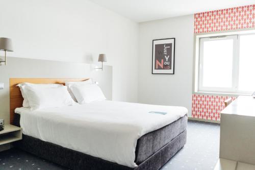 a bedroom with a large bed and a window at Stay Hotel Guimarães Centro in Guimarães