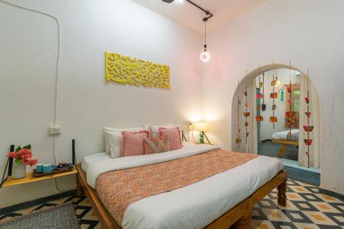 a bedroom with a large bed with pink pillows at StayVista's Suman Vatika - Pench - Outdoor Pool, Rainshower & Terrace in Khawāsa