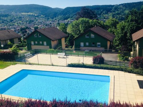 - une piscine en face de certaines maisons dans l'établissement Duplex dans chalet avec superbe vue lac et piscine commune, à Gérardmer