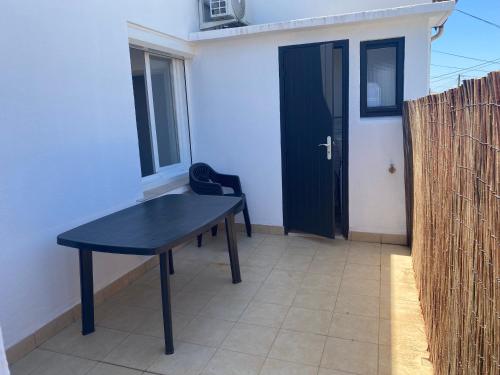 une table noire sur un patio avec une porte dans l'établissement Appartement T2 Valras plage 400m de la plage, à Valras-Plage