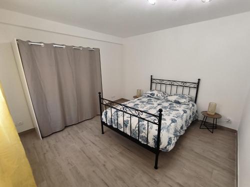 - une chambre avec un lit et un rideau dans l'établissement Appartement pour 2 personnes Mauguio centre, à Mauguio