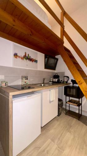 une cuisine avec un comptoir blanc dans un grenier dans l'établissement Lyon 3 - T1 Soignat - HostisY, à Lyon