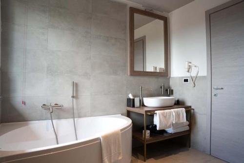 a bathroom with a bath tub and a sink at Le Cappuccinelle Suites&SPA in Perugia