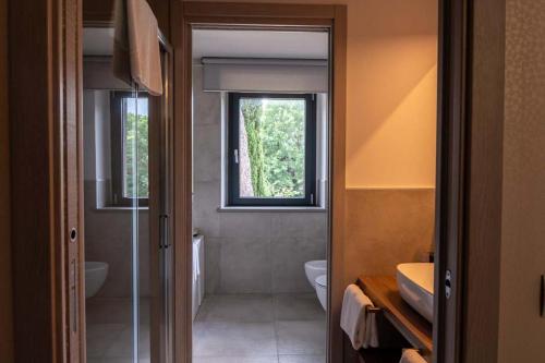 a bathroom with a toilet and a sink and a window at Le Cappuccinelle Suites&SPA in Perugia