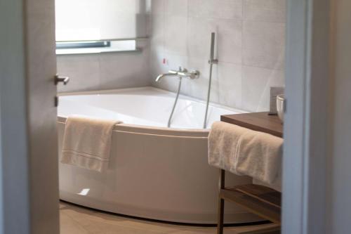 a bathroom with a bath tub with towels on it at Le Cappuccinelle Suites&SPA in Perugia