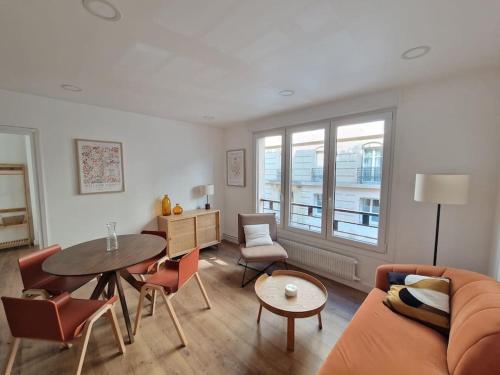 un salon avec un canapé et une table dans l'établissement Élégance moderne 15e - Confort près Tour Eiffel, à Paris