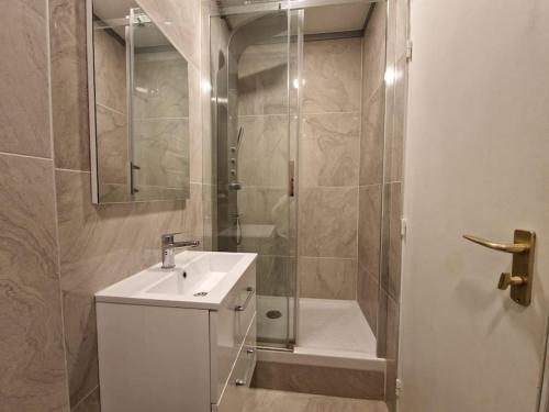 une salle de bain avec un lavabo blanc et une douche dans l'établissement Élégance moderne 15e - Confort près Tour Eiffel, à Paris