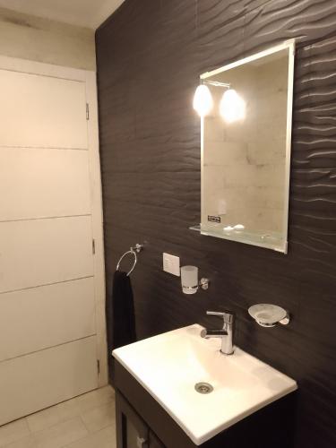 a bathroom with a sink and a mirror at Departamento a estrenar GALO VII in San Bernardo