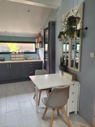 une cuisine avec une table blanche et des chaises dans l'établissement Maison à la campagne, à Haut-Hameau