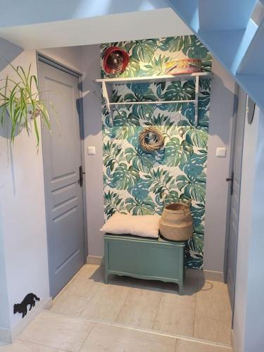 un couloir avec une porte bleue et un mur avec des plantes dans l'établissement Maison à la campagne, à Haut-Hameau
