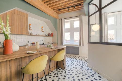 a kitchen with two yellow chairs and a counter at LaBolla, charmant cocon avec spa, cœur de Lyon in Lyon