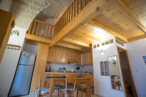 a kitchen with wooden ceilings and a table with chairs at GIORGIa HOUSE in Matino