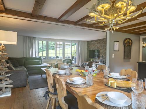 a dining room and living room with a large wooden table at Chalet Chalet am Schärm by Interhome in Lauterbrunnen