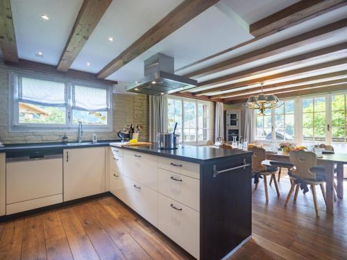 a kitchen with white cabinets and a black counter top at Chalet Chalet am Schärm by Interhome in Lauterbrunnen
