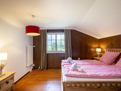 a bedroom with a large bed and a window at Chalet Chalet am Schärm by Interhome in Lauterbrunnen