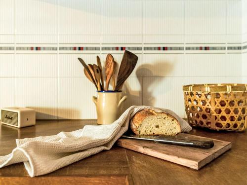 a cutting board with a loaf of bread and a knife at Holiday Home La Formighera by Interhome in Gerra Verzasca