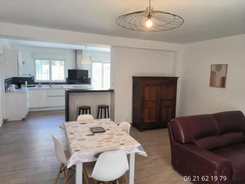 un salon avec une table et un canapé dans l'établissement Appartement pour 2 personnes Mauguio centre, à Mauguio