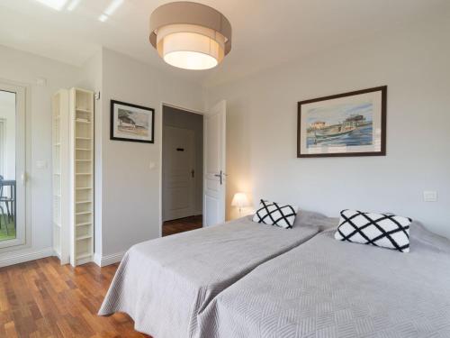 - une chambre blanche avec un grand lit et une lampe dans l'établissement Apartment Villa Symphonie by Interhome, à Arcachon