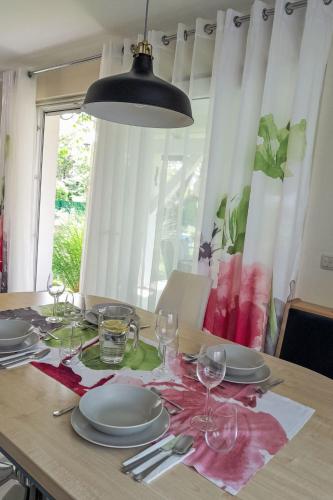 a dining room table with plates and glasses on it at Holiday Home Seehaus Blue Faak by Interhome in Faak am See