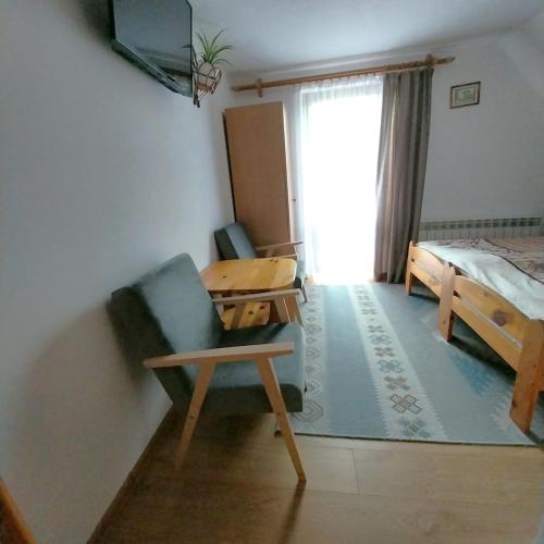 a bedroom with a bed and a chair and a desk at Noclegi u Magdy in Sromowce Wyżne