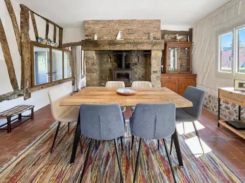 une salle à manger avec une table et des chaises en bois dans l'établissement La Longère Bleue Maison 6 couchages, à Longueil