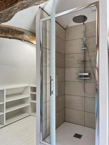 une douche avec une porte vitrée dans une salle de bain dans l'établissement La Longère Bleue Maison 6 couchages, à Longueil