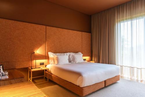 a hotel room with a bed and a large window at Monverde - Wine Experience Hotel - by Unlock Hotels in Amarante