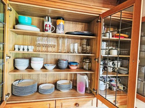 a cabinet filled with plates and bowls and dishes at Holiday Home zur schönen Aussicht by Interhome in Wörgl