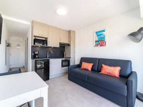 un salon avec un canapé bleu et une cuisine dans l'établissement Studio Les Horizons-8 by Interhome, au Lavandou