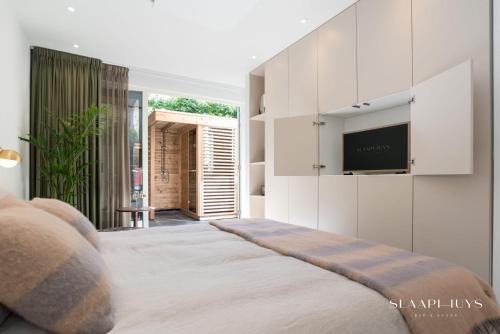a bedroom with a bed with a flat screen tv at Slaaphuys Bed & Sauna in Alkmaar