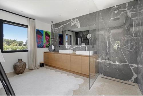 une salle de bain avec un lavabo et une douche en verre dans l'établissement Villa Trémolière, à Saint-Tropez