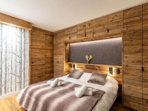 a bedroom with a large bed with wooden walls at Apartment Le Canvolan-1 by Interhome in Tignes